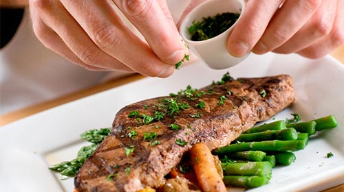 Photo of person seasoning a steak