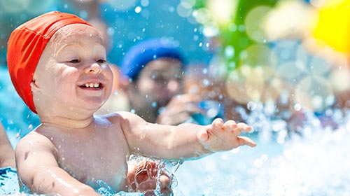 Photo of a boy splashing in a pool