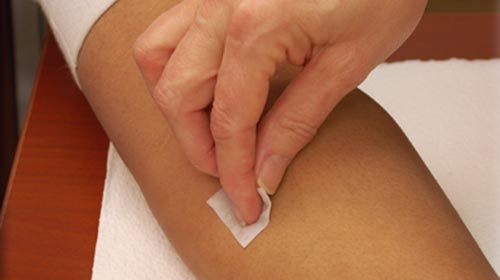 Photo of Nurse placing bandage over TB injection site