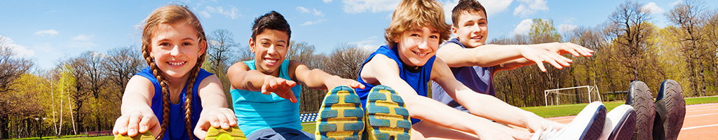 Group of kids on a racetrack stretching in preparation for physical activity