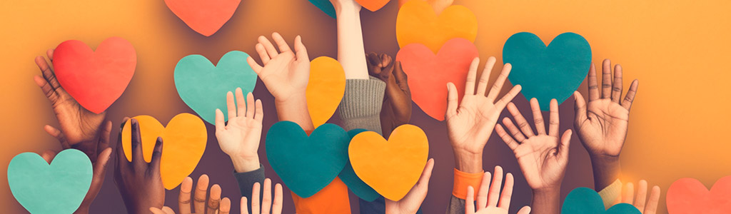 kids hands reaching up with colorful cut out hears around them