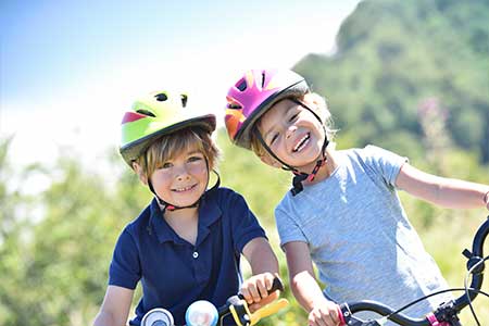 Children on bicycles wearing helmets