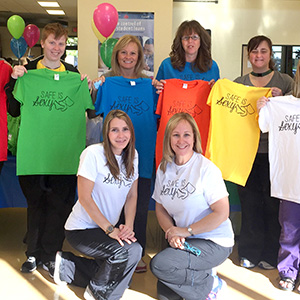 U of W Staff and Students holding "Safe is Sexy" t-shirts