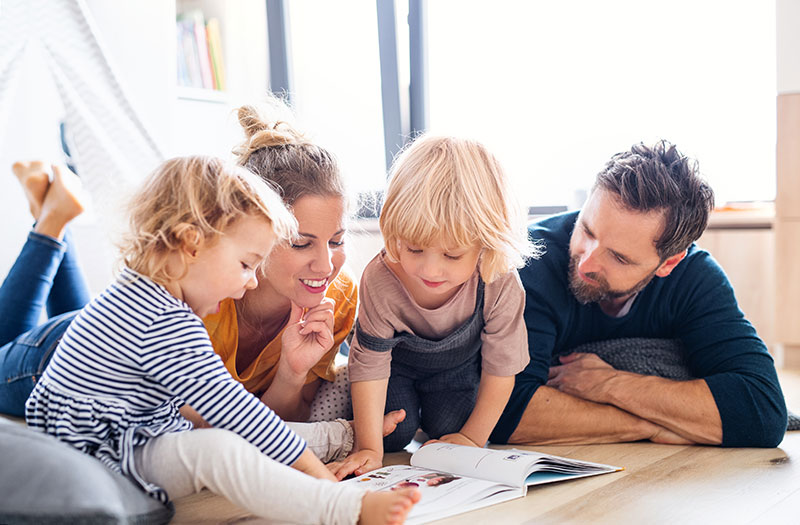 mother and father reading to two young children