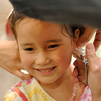 Photo of young girl getting ears pierced