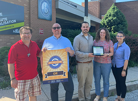 Photo of L'Essor staff being presented with the Gold Status OPHEA certification
