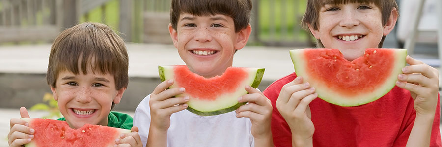 three boys eating a watermelon 