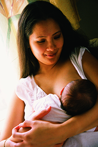 A front view of a woman breastfeeding her baby.